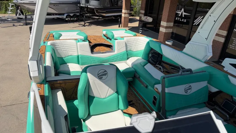 Slide: The Image of The image shows the interior of a 2025 Tigé Ultré 23ZX boat with turquoise seating. - 27