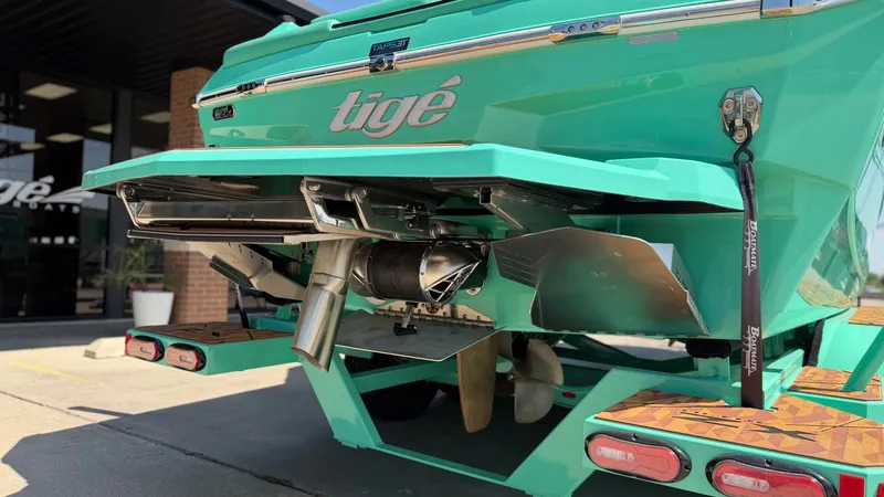 Slide: The Image of The image shows the rear of a turquoise Tigé Ultré 23ZX boat with visible propulsion system. - 10