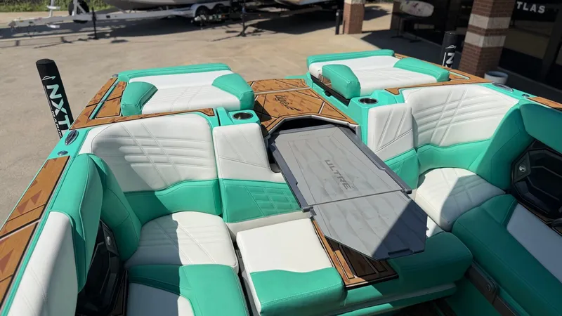 Slide: The Image of The image shows the interior of a Tigé Ultré 23ZX boat with turquoise and white seating. - 18