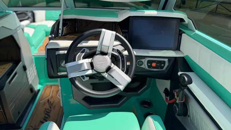Slide: The Image of The cockpit of the 2025 Tigé Ultré 23ZX features a modern steering wheel and a large display. - 23