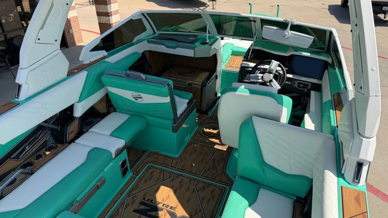 Slide: The Image of The interior of a 2025 Tigé Ultré 23ZX with turquoise and white seating. - 13