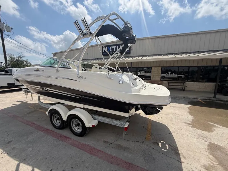 Slide: The Image of A white 2007 Sea Ray 220 Sundeck boat on a trailer in front of a building. - 3