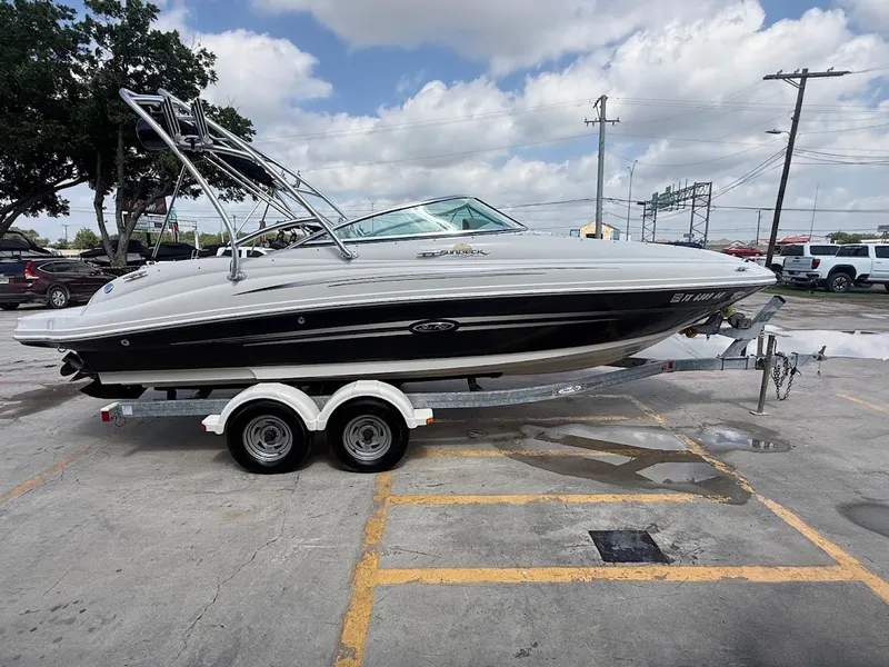 Slide: The Image of A white 2007 Sea Ray 220 Sundeck boat on a trailer in a parking lot. - 6