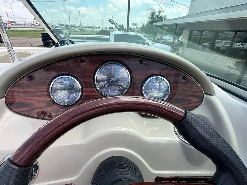 Slide: The Image of The image shows the dashboard of a 2007 Sea Ray 220 Sundeck with wood accents and three round gauges. - 19
