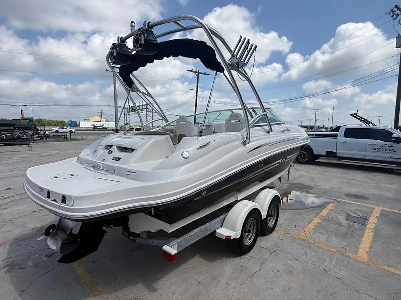Slide: The Image of A white 2007 Sea Ray 220 Sundeck boat on a trailer in a parking lot. - 5