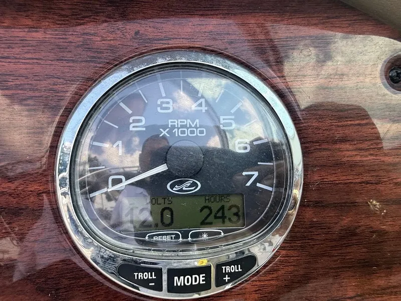 Slide: The Image of Close-up of a tachometer with wood trim, displaying 243 engine hours. - 20