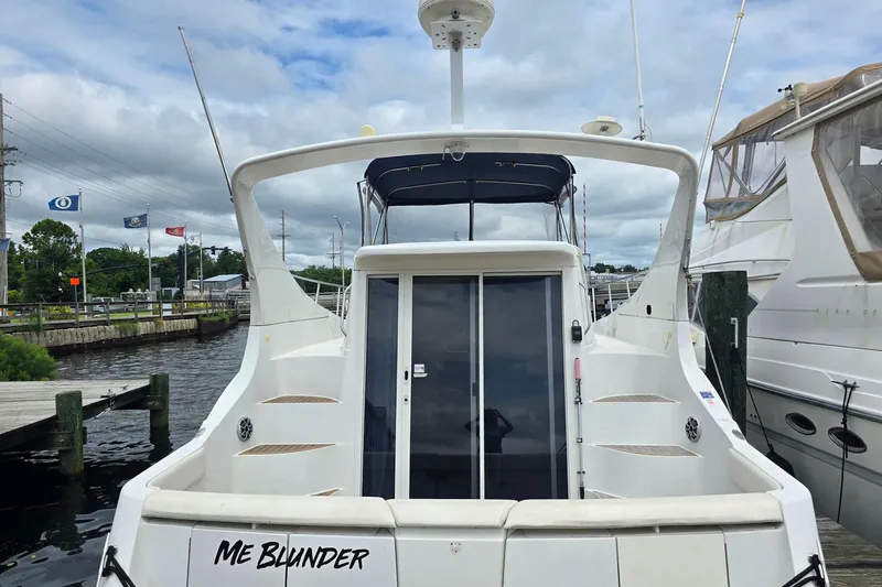 Slide: The Image of 1998 Carver 350 Mariner yacht docked, rear view with sliding doors and overcast sky. - 5