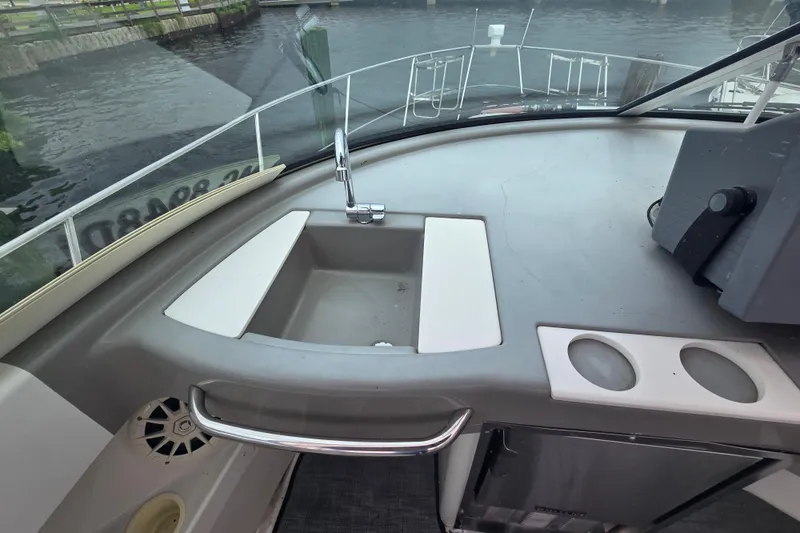 Slide: The Image of 1998 Carver 350 Mariner boat cockpit with sink and cup holders, docked by the water. - 12