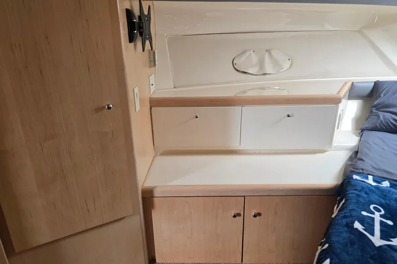 Slide: The Image of Interior cabin of 1998 Carver 350 Mariner with wood cabinetry and nautical-themed bedding. - 33