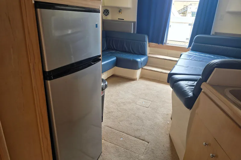 Slide: The Image of Interior of 1998 Carver 350 Mariner yacht with blue seating and compact kitchen. - 40