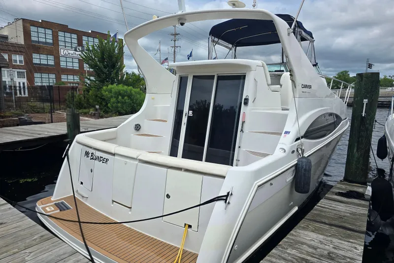 Slide: The Image of 1998 Carver 350 Mariner yacht docked at marina, featuring sleek design and spacious deck. - 4