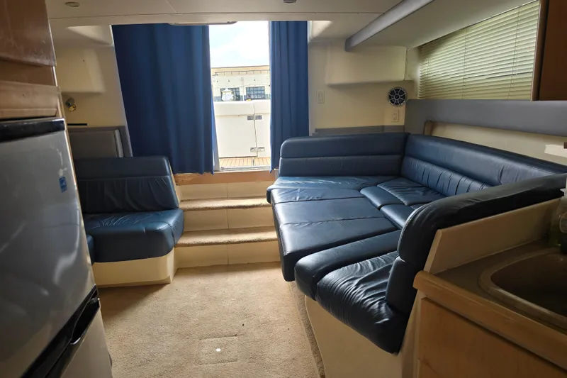 Slide: The Image of Interior of 1998 Carver 350 Mariner yacht with blue seating and carpeted floor. - 21