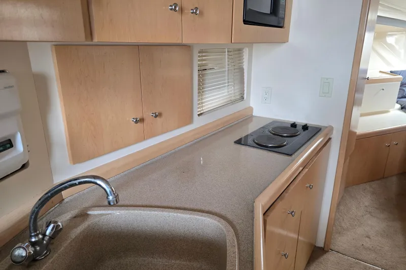 Slide: The Image of 1998 Carver 350 Mariner kitchen with sink, stove, and wooden cabinets. - 31