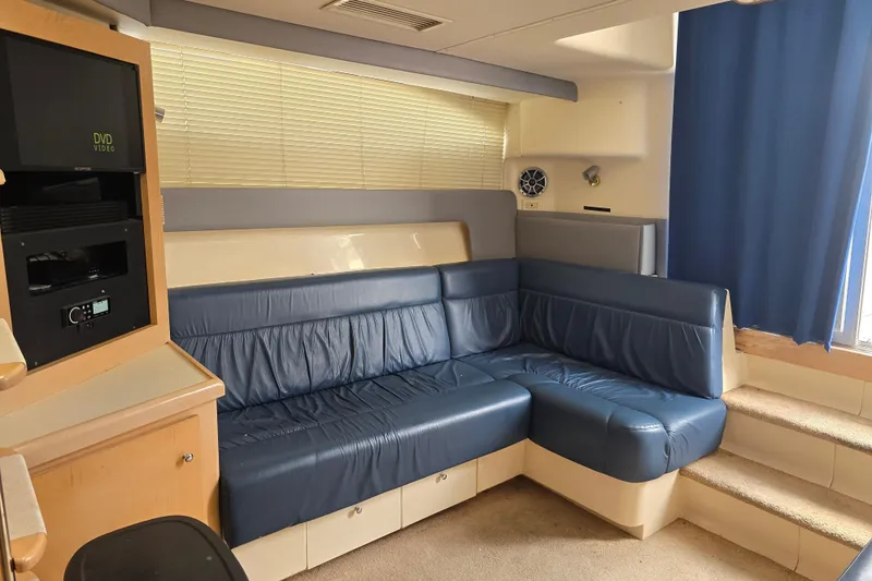 Slide: The Image of Interior of a 1998 Carver 350 Mariner yacht with blue leather seating and entertainment system. - 22
