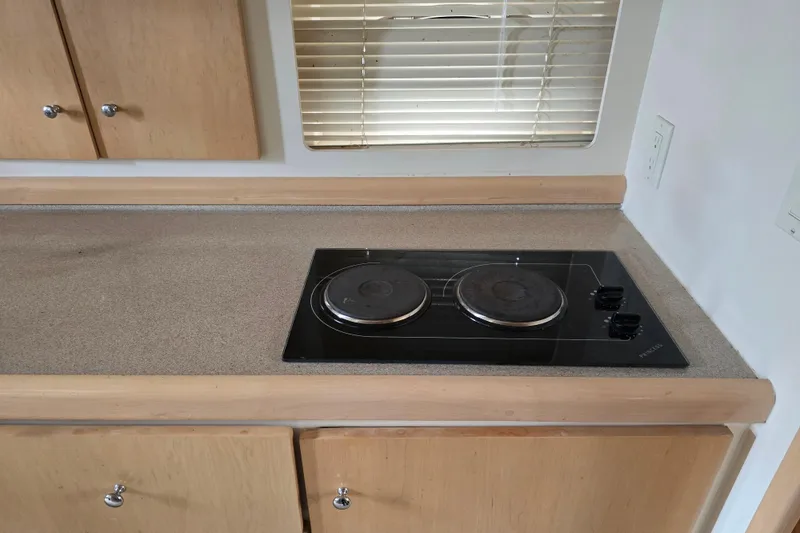Slide: The Image of 1998 Carver 350 Mariner kitchen with electric stove and wooden cabinets. - 30
