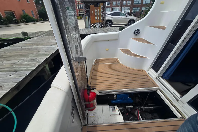 Slide: The Image of 1998 Carver 350 Mariner boat deck with open engine hatch and dock view. - 16