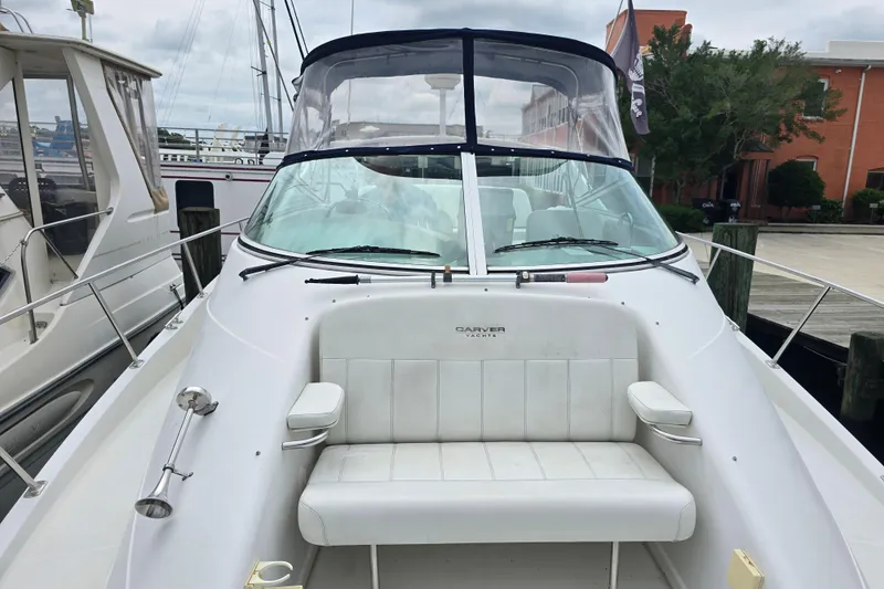 Slide: The Image of 1998 Carver 350 Mariner yacht docked, featuring a spacious seating area and clear canopy. - 7