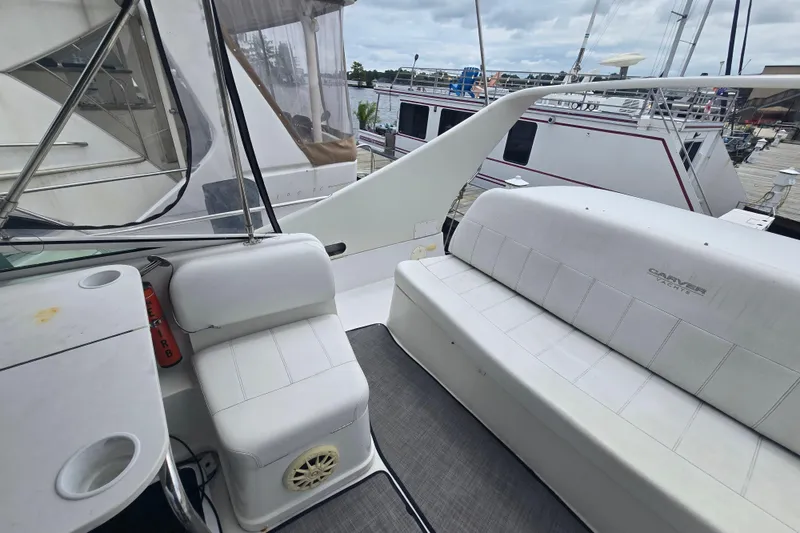 Slide: The Image of 1998 Carver 350 Mariner yacht interior with white seating and marina view. - 13