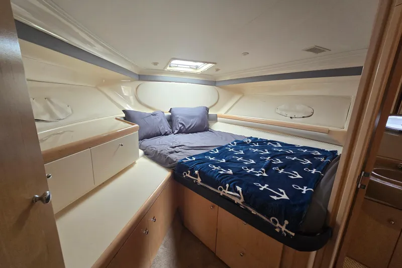 Slide: The Image of Cozy cabin interior of 1998 Carver 350 Mariner with bed and nautical-themed blanket. - 32
