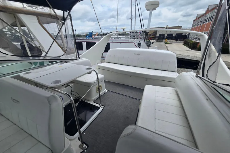 Slide: The Image of 1998 Carver 350 Mariner yacht interior with white seating and table, docked at marina. - 9