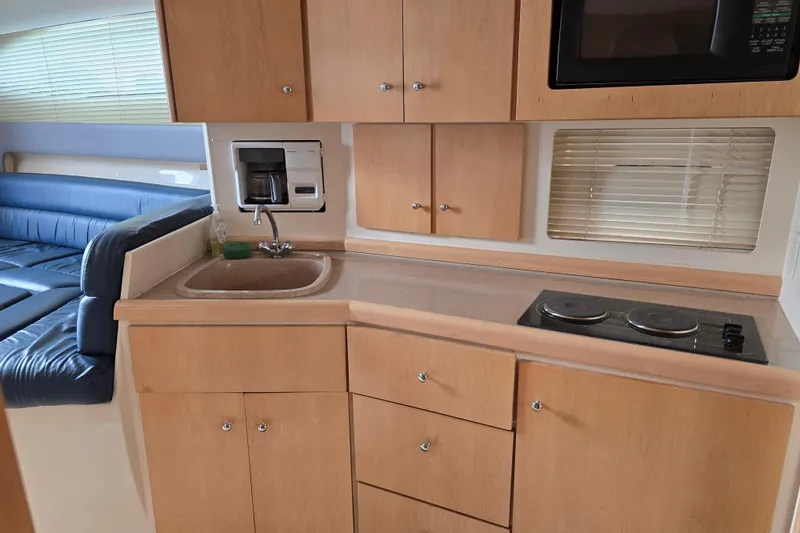 Slide: The Image of 1998 Carver 350 Mariner kitchen with sink, stove, microwave, and seating area. - 27