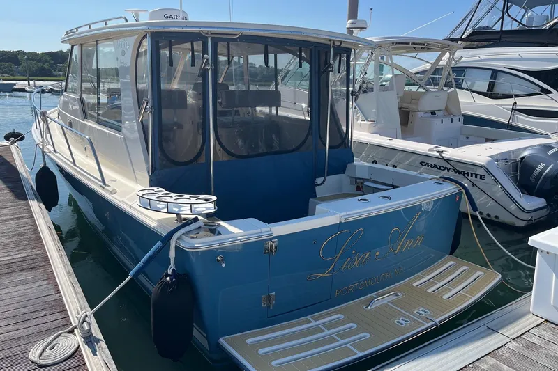 Slide: The Image of 2007 Mainship Pilot 34 Sedan docked at marina, featuring blue and white exterior. - 3