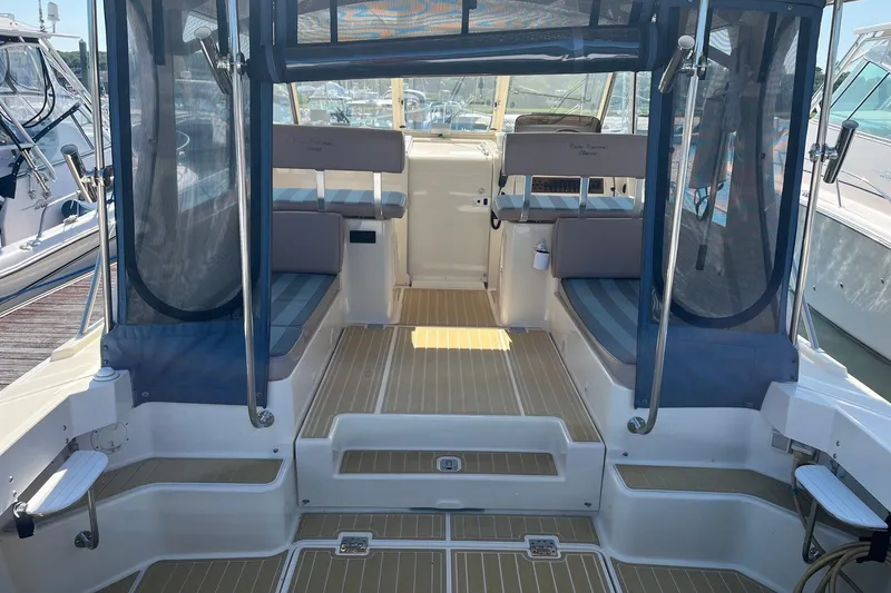 Slide: The Image of The image shows the cockpit of a 2007 Mainship Pilot 34 Sedan with blue cushions and a clear canopy. - 4