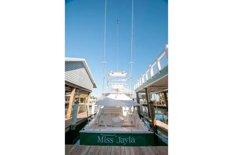 Slide: The Image of 2004 Cabo 40 Express yacht docked, named "Miss Jayla," under clear blue sky. - 15