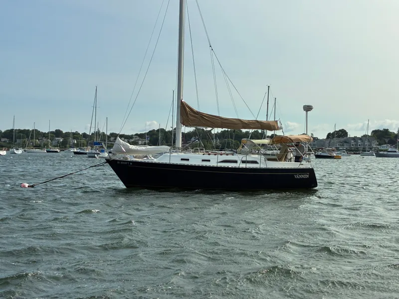 The Image of A 1986 Freedom Yachts 30 is anchored in a busy harbor. - 0