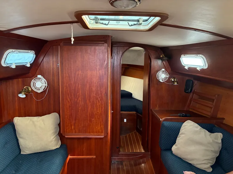Slide: The Image of Interior of a 1986 Freedom Yachts 30 with wood paneling and blue upholstery. - 23