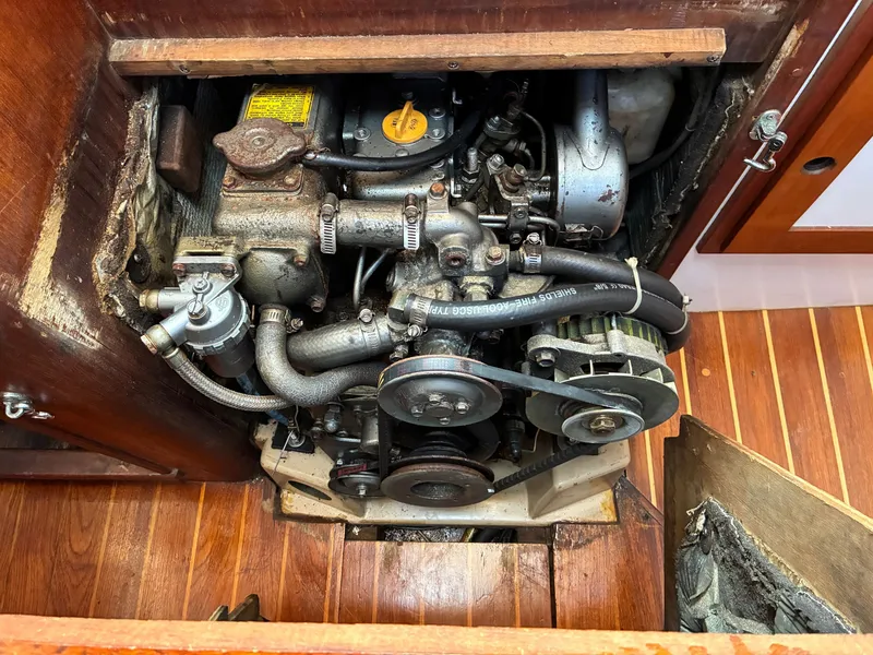 Slide: The Image of An engine compartment with an older engine in a wooden frame, surrounded by wood flooring. - 42