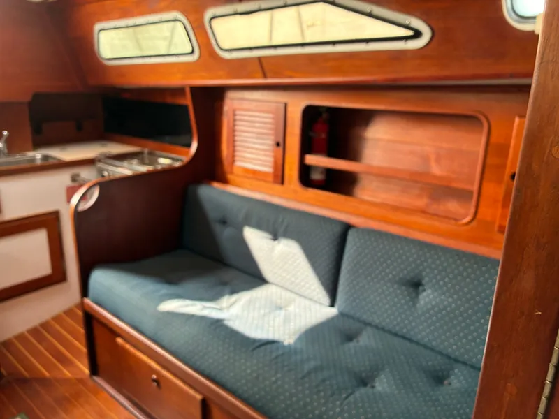 Slide: The Image of The image shows the interior of a 1986 Freedom Yachts 30 with a blue couch. - 28