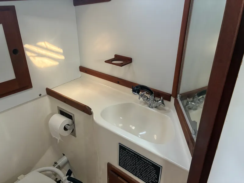 Slide: The Image of The image shows a yacht bathroom with a sink, mirror, and wooden trim. - 39