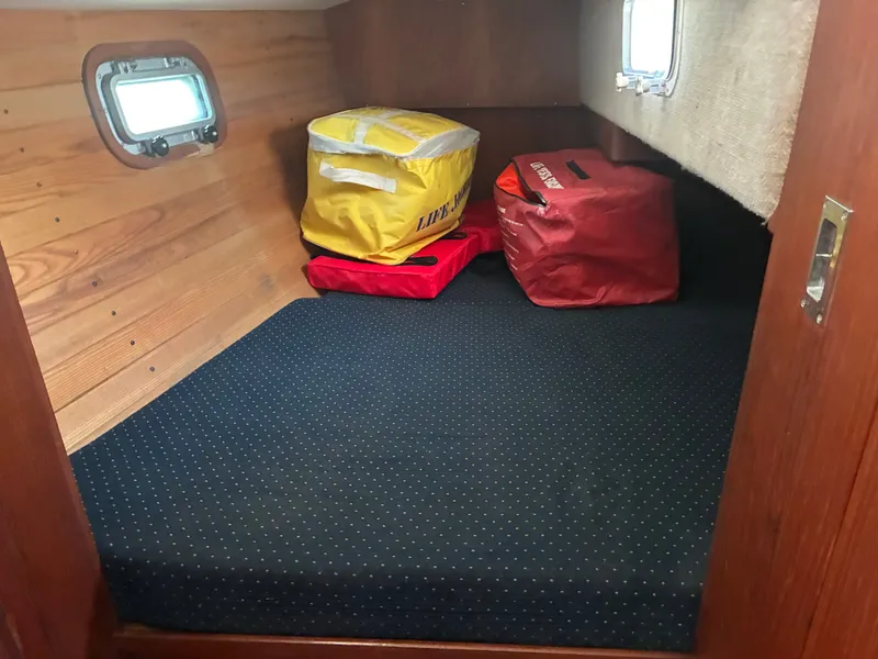 Slide: The Image of The cabin of a 1986 Freedom Yachts 30 with a dotted cushion and two bags. - 37
