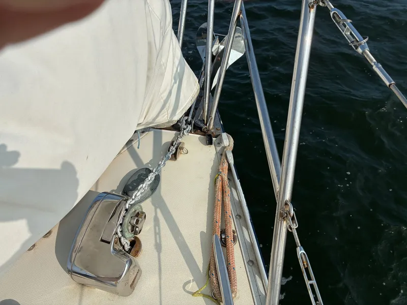 Slide: The Image of A sailboat with stainless steel railing and anchor windlass, positioned on calm water. - 14