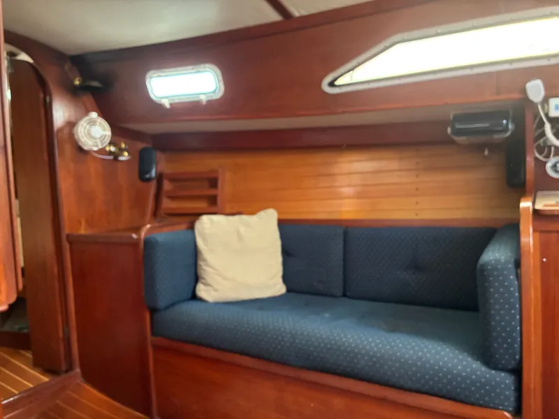 Slide: The Image of Interior of a 1986 Freedom Yachts 30 with wooden walls and a blue couch. - 26