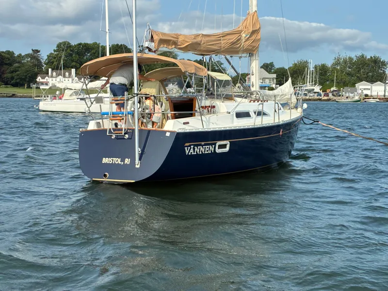 Slide: The Image of A 1986 Freedom Yachts 30 sails on calm waters, featuring a blue hull design. - 2
