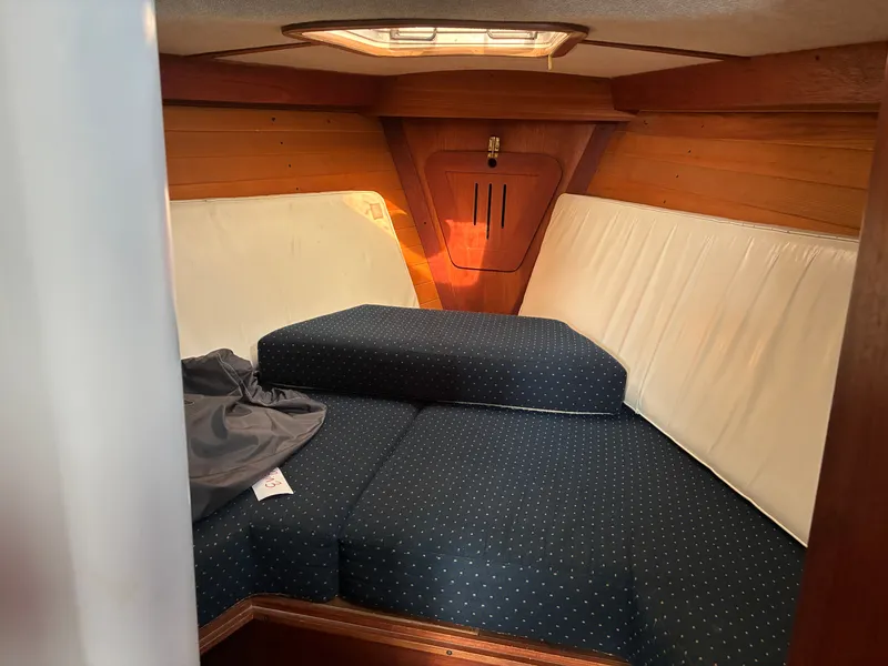 Slide: The Image of Interior of a 1986 Freedom Yachts 30 with cushioned seating and wood paneling. - 34