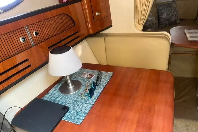 Slide: The Image of Interior of 2006 Sea Ray Sundancer 280 with wooden table, lamp, and sunglasses. - 15