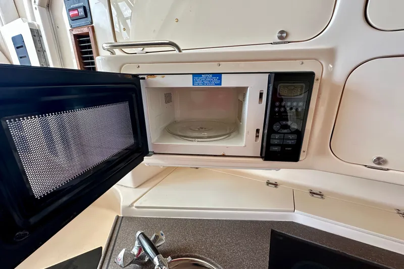 Slide: The Image of Microwave in 2007 Grady-White Express 330 boat kitchen, open door, control panel visible. - 99