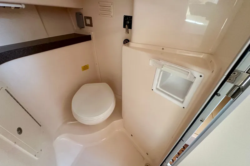 Slide: The Image of 2007 Grady-White Express 330 boat bathroom interior with toilet and storage compartment. - 88