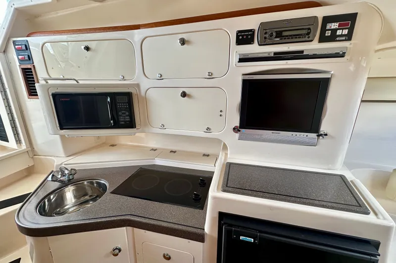 Slide: The Image of 2007 Grady-White Express 330 boat interior with kitchenette, microwave, sink, and electronic equipment. - 103