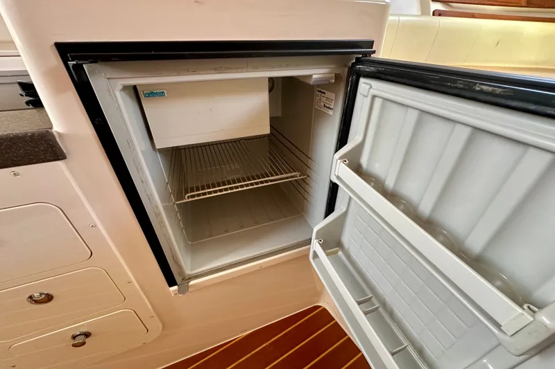 Slide: The Image of Open refrigerator inside 2007 Grady-White Express 330 boat, showcasing interior shelving. - 96