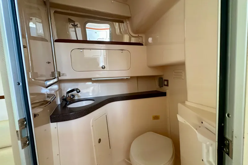 Slide: The Image of 2007 Grady-White Express 330 boat bathroom with sink, toilet, and storage cabinets. - 79