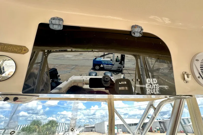 Slide: The Image of 2007 Grady-White Express 330 boat interior with "Old Guys Rule" sticker, reflecting outdoor scene. - 65