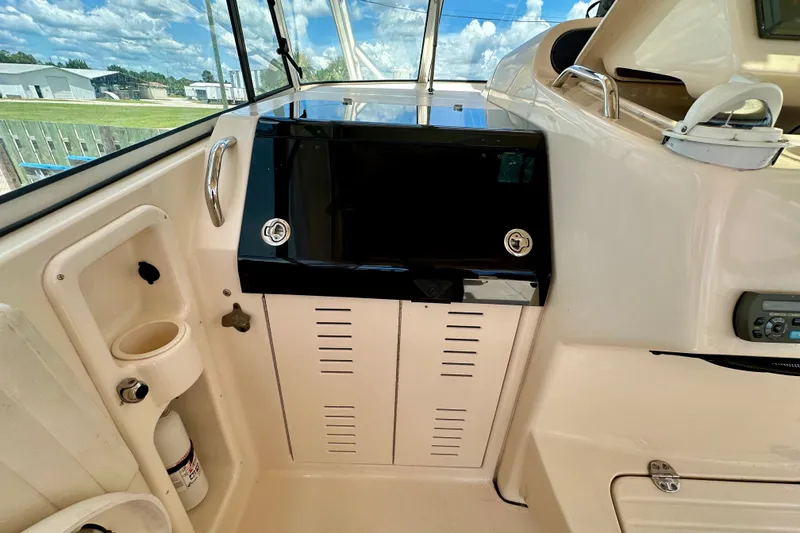 Slide: The Image of 2007 Grady-White Express 330 boat interior with control panel and storage compartments. - 73