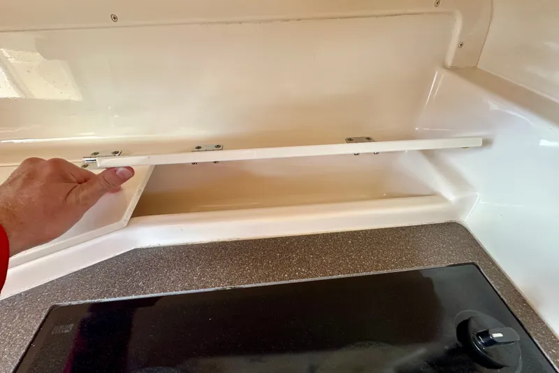 Slide: The Image of Hand opening storage compartment on 2007 Grady-White Express 330 boat interior. - 97