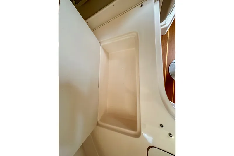 Slide: The Image of Interior compartment of 2007 Grady-White Express 330 boat, featuring a clean, white storage area. - 90