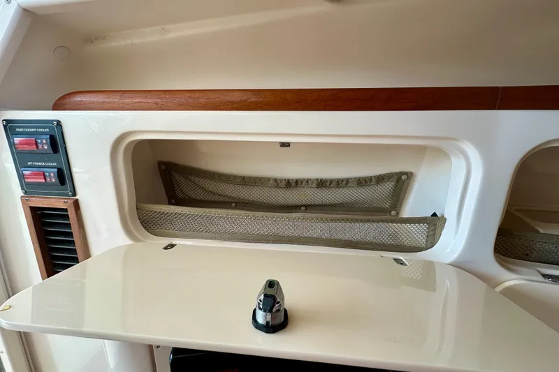 Slide: The Image of 2007 Grady-White Express 330 interior storage compartment with mesh netting and control panel. - 100