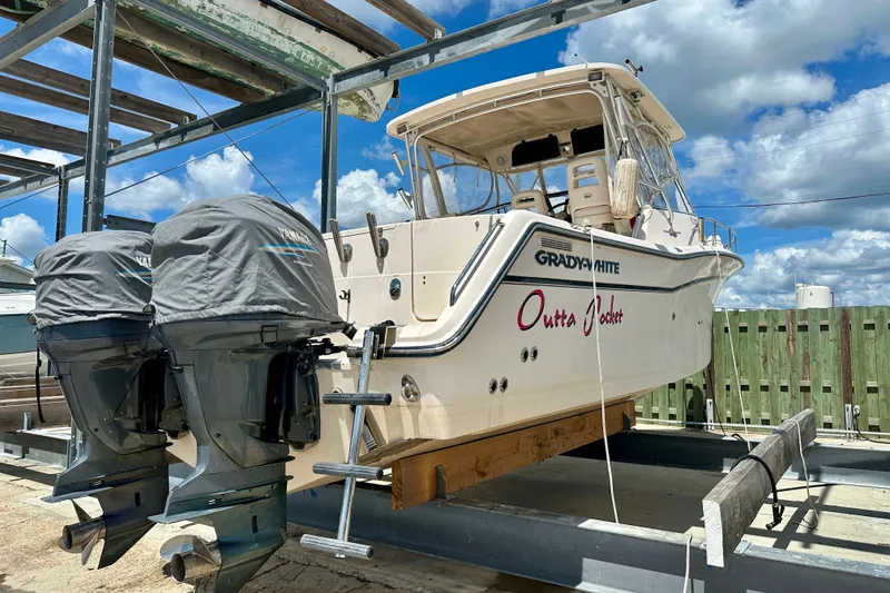 Slide: The Image of 2007 Grady-White Express 330 boat with dual Yamaha engines on a lift, under a blue sky. - 18